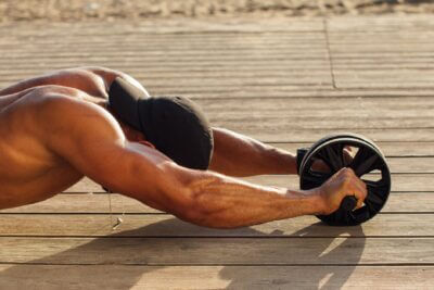 Man using a roller for abs workout. Does abs workout make you shorter?