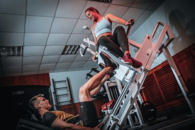 man doing leg presses with a woman seated atop. Best leg exercises.